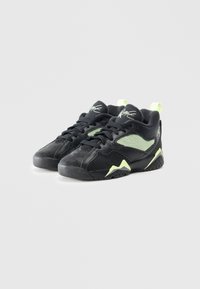 Scarpe da ginnastica nere con accenti verdi, pannelli in rete e sovrapposizioni nere testurizzate. Presentano un colletto imbottito e una suola in gomma con trazione.