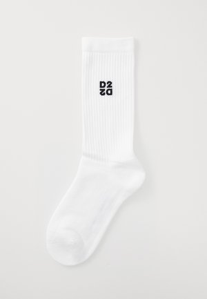 Chaussettes blanches côtelées avec un logo "D2Z0" noir sur le côté. Fabriquées à partir d'un tissu doux avec des zones renforcées au niveau des orteils et du talon.