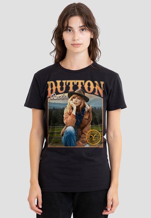 Schwarzes T-Shirt mit einem grafischen Druck einer im Freien sitzenden Frau, mit "DUTTON" und "Beth" in orangefarbener Schrift oben.