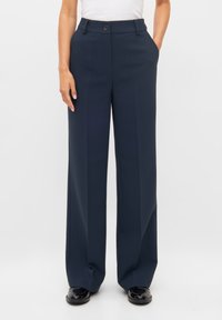 Navy wijde broek gemaakt van soepel materiaal, met voorkruiszakken, een knoopsluiting en een minimalistisch ontwerp.