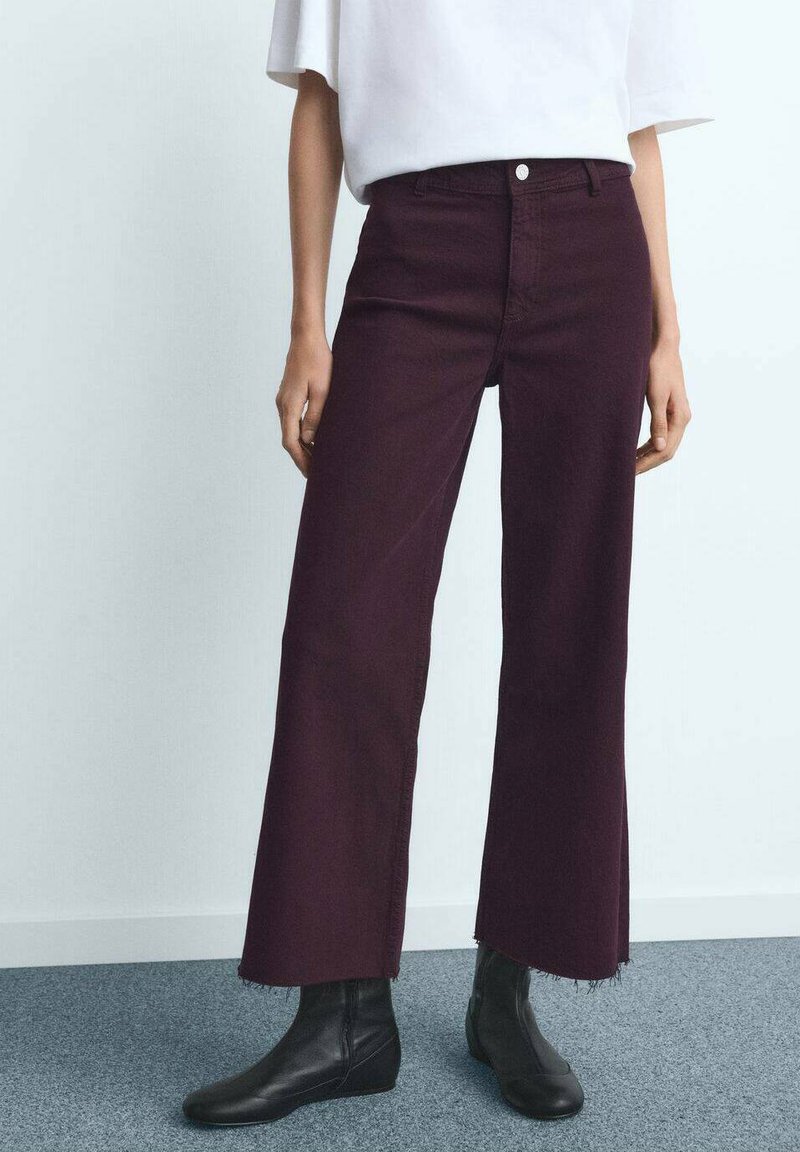 Bordo kavbojke širokih hlačnic z neobdelanim robom, iz jeansa, z značilnim klasičnim dizajnom s petimi žepi in sprednjo zaponko na gumbe.