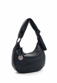 Sac à bandoulière en cuir noir avec une poignée rembourrée et torsadée, fermeture éclair et étiquette ronde en métal avec logo suspendue sur un côté.