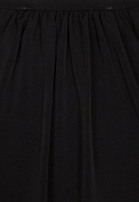 Tessuto nero con texture arricciata, caratterizzato da una leggera elasticità e una superficie liscia. Mostra cuciture uniformi e un aspetto morbido e leggero.