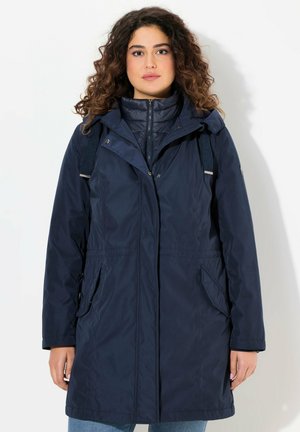 Navy blue vedenäkevä takki, jossa on huppu, vetoketjusulku, joustava vyötärö ja kaksi sivutaskua. Sileä rakenne ja nailonmateriaali.