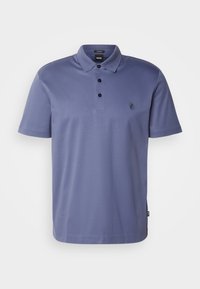 Polo tričko v tlumené fialové barvě, vyrobené z hladké látky, s třemi knoflíky a malým logem na levé hrudi. Krátké rukávy.