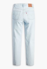 Jean en denim bleu clair vu de dos avec deux poches, un patch en cuir marron de la marque et une étiquette en tissu rouge sur la poche droite.