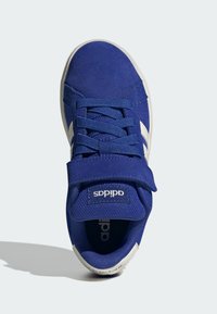 Blå mockaskor med vita ränder, snörningsdesign, vadderad tunga och kardborreband. Har en texturerad sula för bättre grepp.