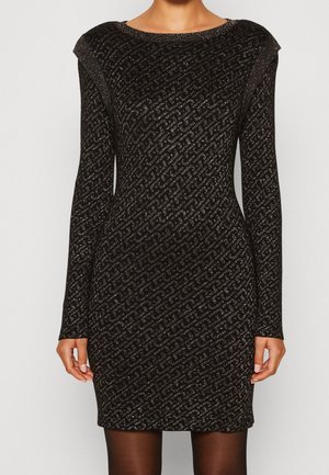 Fitted black long-sleeve dress with glittery diagonal chain pattern and shoulder accents, worn with sheer black tights.