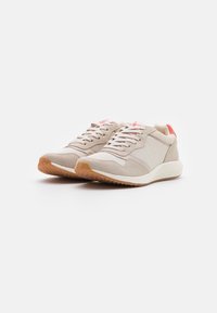 Sneaker beige con una combinazione di camoscio e mesh, con una suola in gomma testurizzata e un accento rosa sul tallone. Design con lacci.