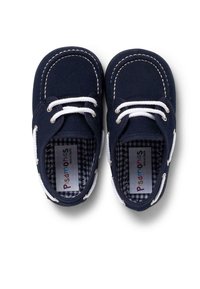 Marineblaue Segelschuhe aus Canvas mit weißen Schnürsenkeln, gesteppten Akzenten und einem karierter Innenfutter. Besitzen eine glatte Textur und ein rundes Design der Zehenpartie.