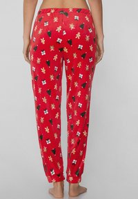 Czerwone spodnie od piżamy o miękkiej fakturze, z świątecznymi wzorami zielonych choinek, prezentów i figurek piernikowych. Elastyczny pas.