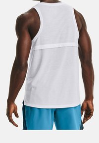 Biały sportowy top na ramiączkach z siateczkowym wzorem, z solidną górną częścią i perforowaną dolną połową, minimalnymi szwami oraz zaokrąglonym dołem.