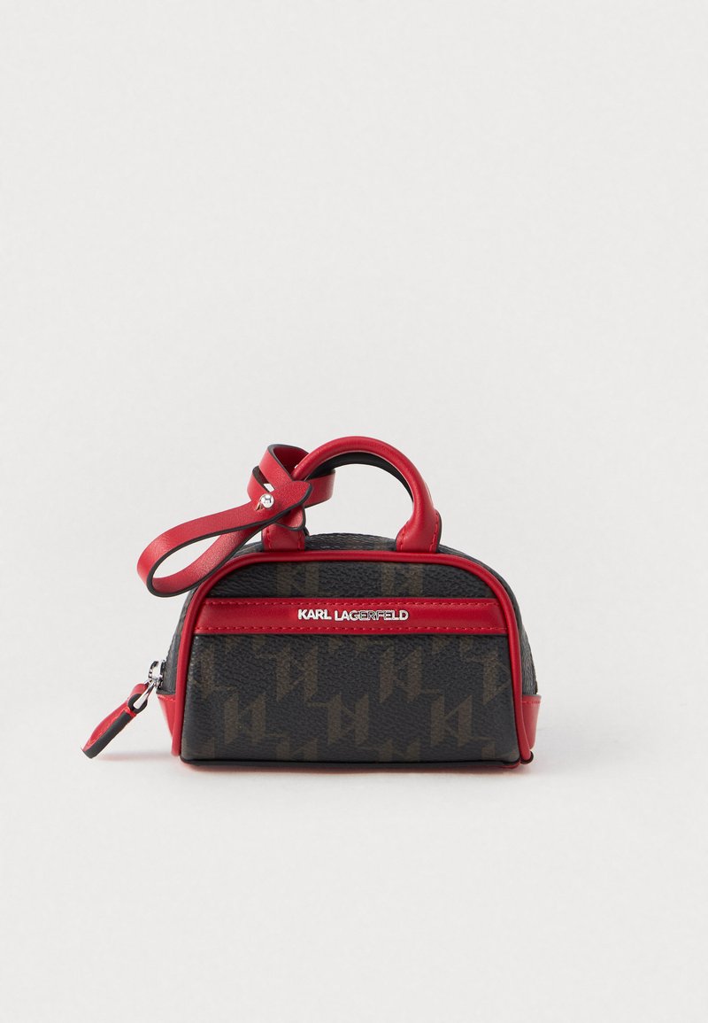 Kis fekete és barna táska piros díszítéssel, felső fogantyúval, cipzárral és ezüst "Karl Lagerfeld" logóval elöl.