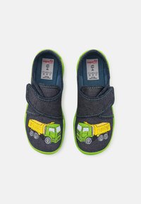 Denim slip-on sko med grønn gummisåle, med broderte gule og grønne lastebiler på hver sko og borrelås for lukking.