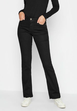 Jean en denim noir avec une coupe droite, dotée d'une fermeture à bouton, de poches avant et d'une texture lisse. Associé à des baskets blanches.