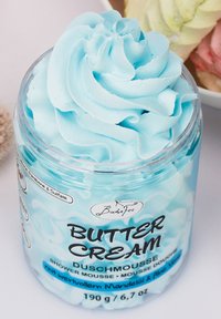 Light blue shower mousse in a clear jar with a textured, whipped top. Label features bold black text. Contains 190g of product.