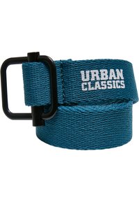 Tyrkysový pletený opasok s čiernou kovovou prackou, na traku s bielym potlačeným nápisom "URBAN CLASSICS". Texturovaná tkanina s odolným prešívaním.