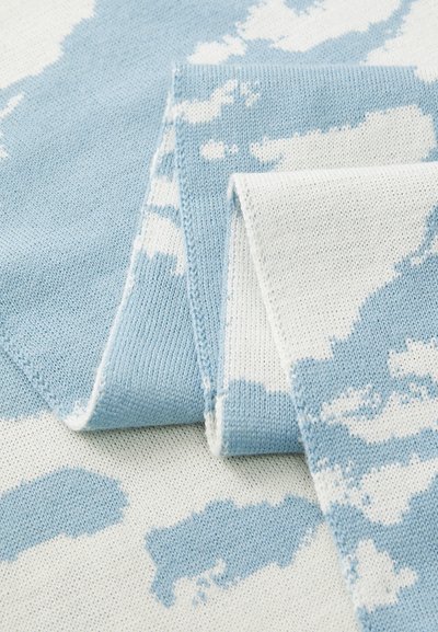 Tecido tricotado em azul suave e branco com um padrão abstrato semelhante a nuvens, dobrado para mostrar a textura e os detalhes de costura.
