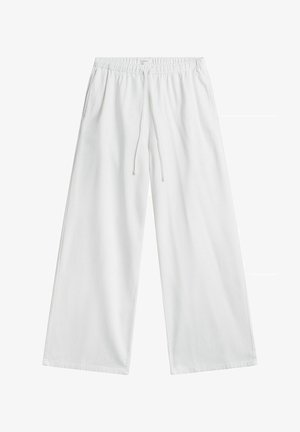 Witte wijde broek met elastische tailleband en trekkoord, voorzien van zijzakken, plat liggend op een witte achtergrond.