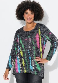 T-shirt noir à manches longues avec un motif abstrait coloré dans des teintes de rose, vert, bleu et jaune, avec un col arrondi et un ourlet incurvé.