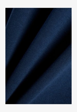 Dunkelblauer Stoff mit feiner Strickstruktur, dargestellt in weichen Falten, die Licht- und Schattenkontraste erzeugen.