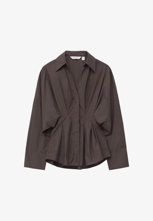Donkerbruine blouse met lange mouwen en een puntige kraag, geplooide details langs de voorkant en zijkanten, en een licht-uitlopende zoom.
