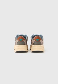 Καφέ και γκρι αθλητικά παπούτσια από δίχτυ και σουέντ, με επενδυμένη γλώσσα, μπλε λεπτομέρειες και ελαφριά μπεζ λαστιχένια σόλα.