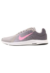 Scarpa da corsa grigia con tomaia in rete testurizzata e swoosh rosa di Nike. Presenta una intersuola bianca e suola in gomma nera. Design a profilo basso.