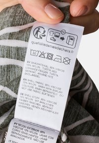 Tessuto grigio con strisce bianche, contenente un'etichetta di cura che mostra istruzioni di lavaggio in diverse lingue. Materiale: 85% viscosa, 15% nylon.