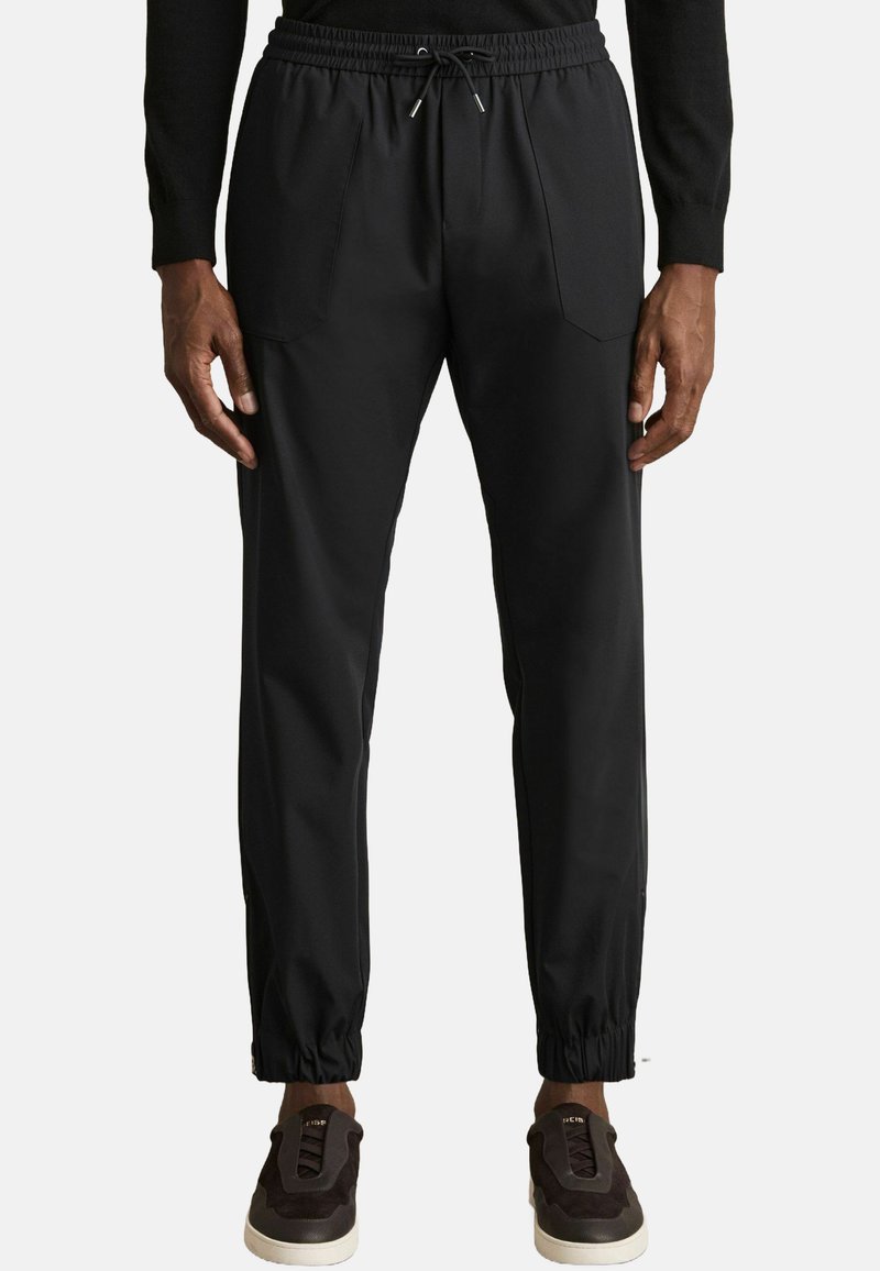 Pantaloni sport de culoare neagră, cu un brâu elastic și detalii cu șnur. Au picioare conice cu mansete elastice și două buzunare frontale.