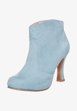 Jasnoniebieski zamszowy botek za kostkę z okrągłym noskiem, wysokim drewnianym obcasem i minimalnymi detalami szycia. Gładka struktura i dopasowany fason.