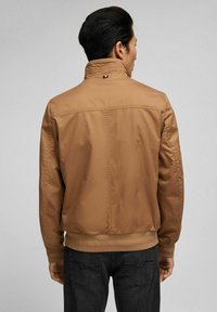 Braune, leichte Bomberjacke mit hohem Kragen, elastischen Bündchen und Saum sowie glatter Textur. Auf der Rückseite befindet sich ein Logo am Kragen.