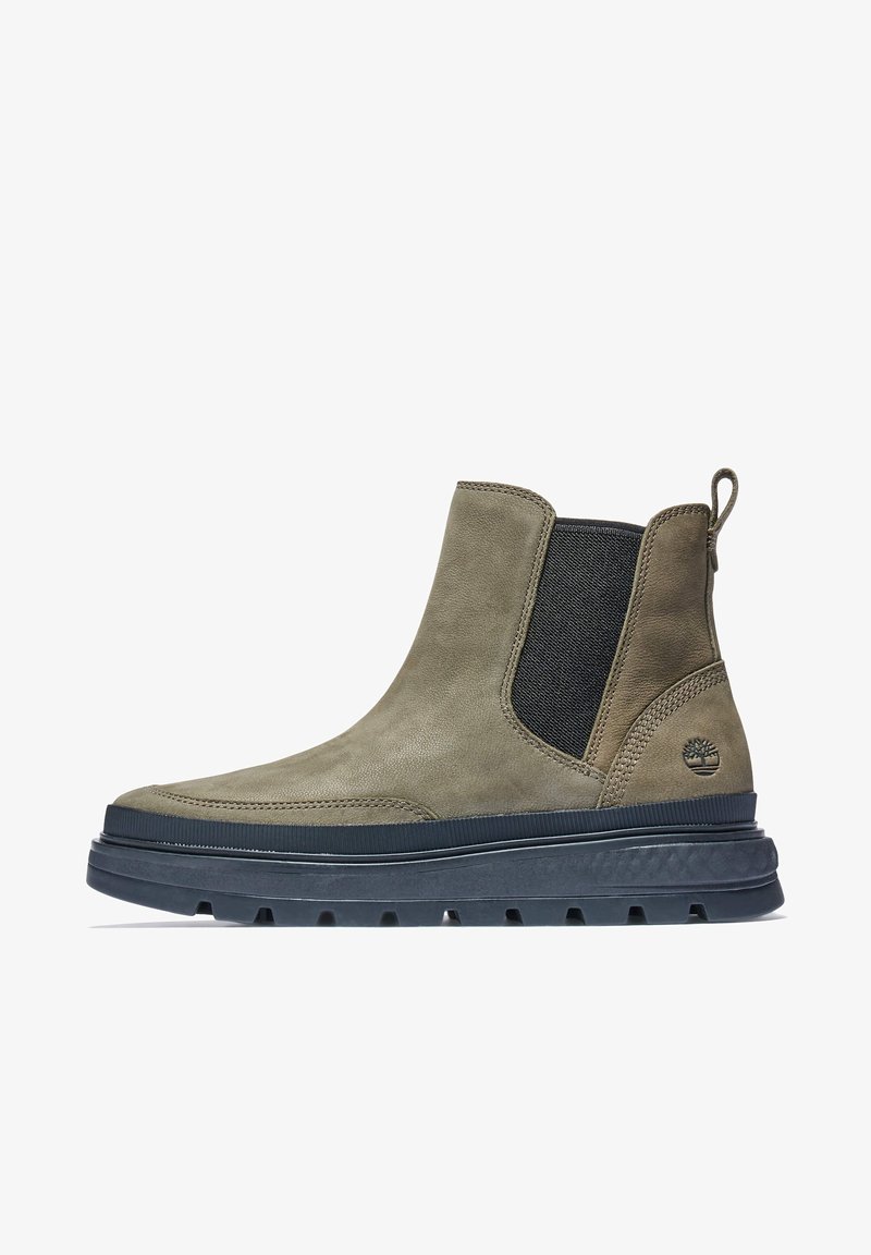 Botte Chelsea en daim vert olive avec panneaux latéraux élastiques, languette de traction et semelle en caoutchouc noir texturée présentant un motif de crampons.