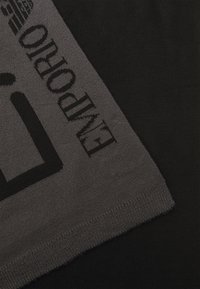 Écharpe noire avec une section tricotée grise comportant le texte "ENVIRO" et des motifs géométriques. Texture lisse avec des couleurs contrastées.