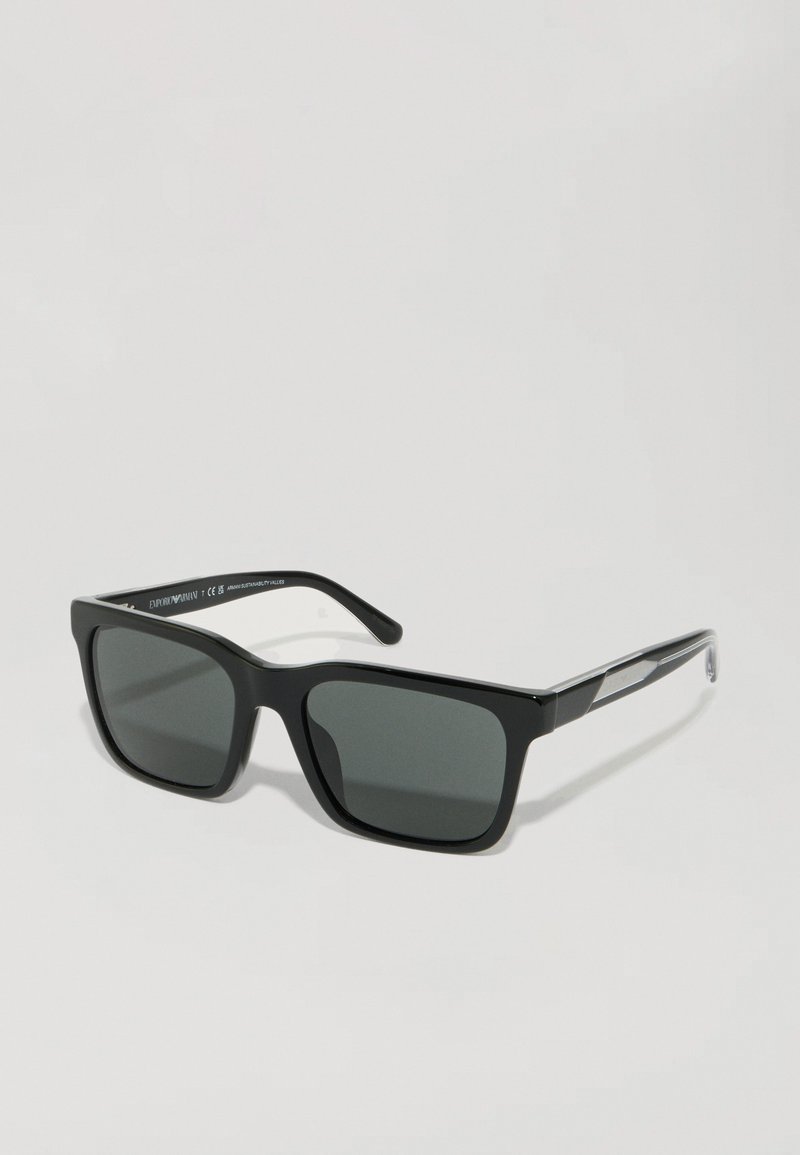 Ochelari de soare negri în formă de pătrat, cu lentile gri, rame din plastic și accente argintii pe tâmple. Vedere frontală cu un design minimalist.