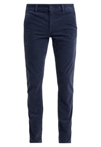 Laivastonsiniset samettinahirushousut, kapealla istuvuudella, joissa on nappikiinnitys, vyölenkit ja kaksi sivutaskua. Teksturoitu kangas pystysuorin uurtein.