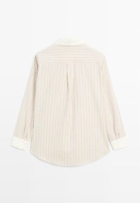Striped button-up shirt featuring a light beige base with blue and purple stripes, white collar, and buttoned cuffs, with a pleated back design.