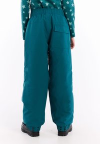 Teal nepromokavé sněhové kalhoty s elastickým pasem, boční kapsou a nastavitelnými manžetami. Hladký povrch a volný střih pro pohodlí.