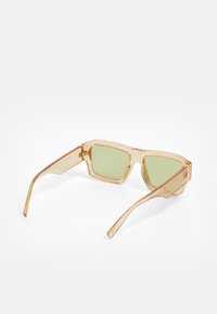 Translucent amber sunglasses with green lenses, rectangular shape, thin arms, and metallic accents at the hinge. Light and modern design.