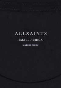 Black fabric tag with white text reading "ALLSAINTS," size "SMALL," and "MADE IN CHINA." Simple, rectangular shape, slightly textured.