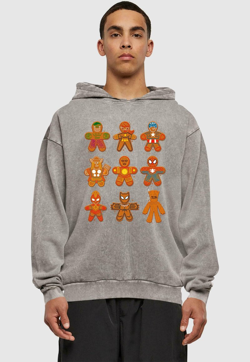 Sudadera gris con figuras de jengibre coloridas y de estilo caricaturesco que representan a varios superhéroes, mostradas de forma destacada en la parte delantera.