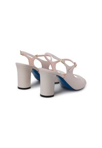 Scarpe slingback sintetiche rosa con punta arrotondata, tacco a blocco bianco largo e dettagli in oro. Presentano una parte posteriore aperta e ritagli laterali.