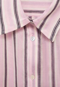 Skjorta med krage i rosa, krämfärg och svarta vertikala ränder. Lättviktig tyg med en subtil textur, med knappstängning.