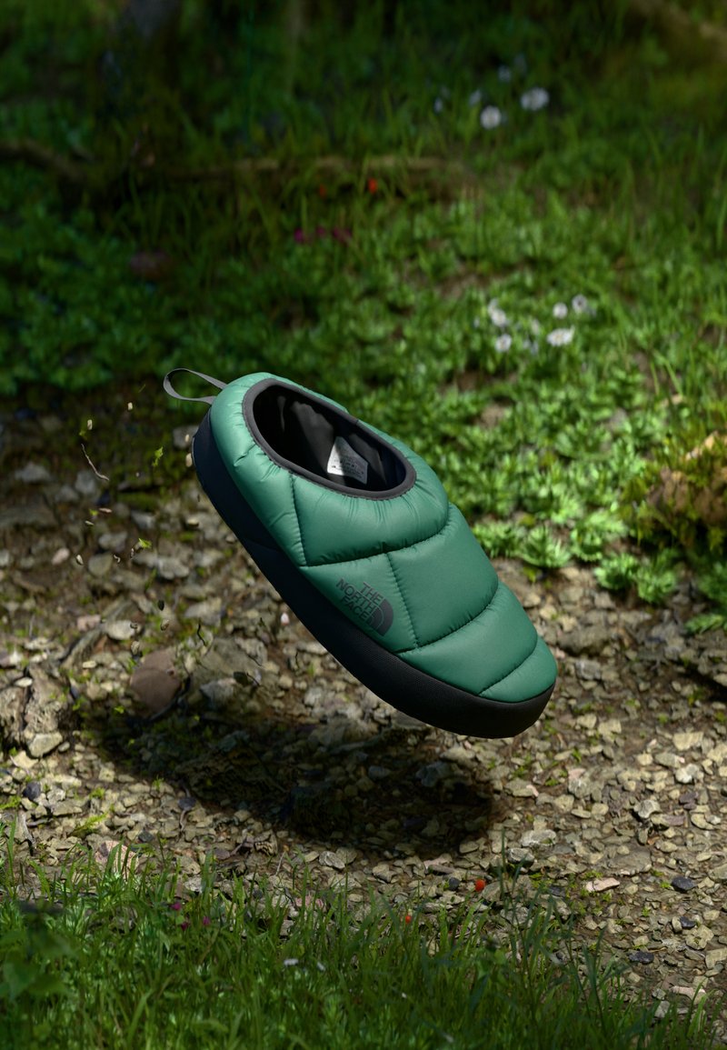 Green, quilted slip-on shoe with a rounded toe and black rubber sole. Features a pull tab for easy wear and minimalistic design.