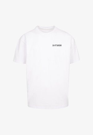 Valge puuvillane T-särk, millel on ümar kaelus ja lühikesed varrukad, ülemises vasakus nurgas on musta värviga print "ZY STUDIOS".