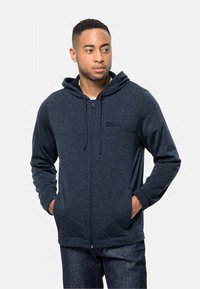Felpa zip con cappuccio blu navy, con cordino, logo sul petto e tasche frontali. Realizzata in tessuto morbido e testurizzato, adatta per un look casual.
