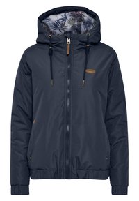 Giacca a vento blu navy con interno a fantasia floreale, chiusura con zip, cappuccio regolabile e polsini elasticizzati. Presenta dettagli color beige e logo.