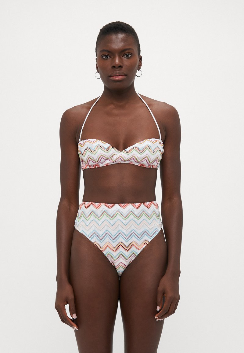 Bikini set featuring a bandeau top and high-waisted bottom. Patterned with multicolored zigzag stripes on a light background. Soft fabric.