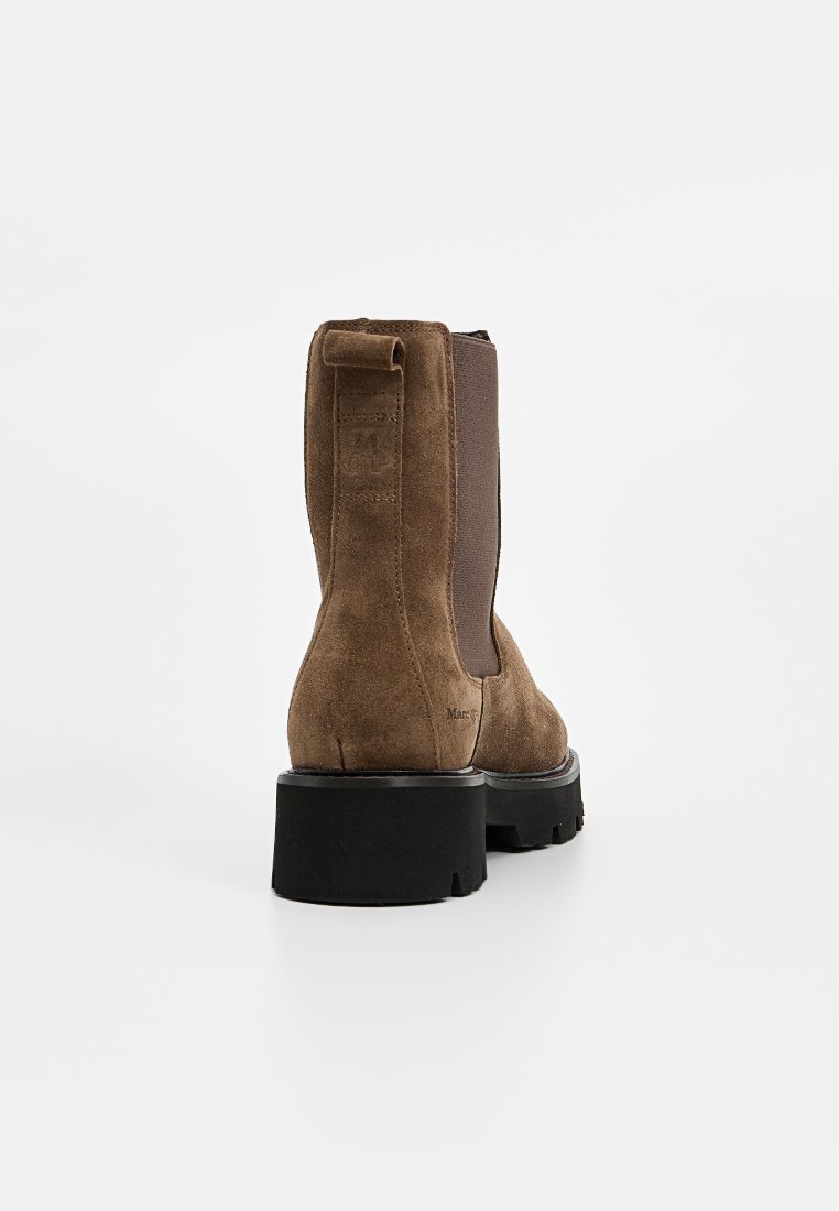 Braune Wildleder-Ankle Boots mit elastischen Seitenpaneelen, runder Zehenpartie und einer klobigen schwarzen Gummisohle. Hintere Schlaufe für einfaches Anziehen.
