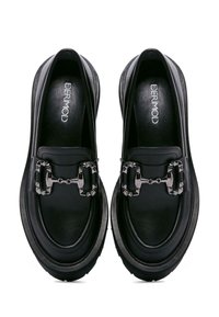 Mocassins en cuir noir avec des accents en chaîne, bout arrondi, semelle en caoutchouc épaisse et texture lisse. Marque visible à l'intérieur.